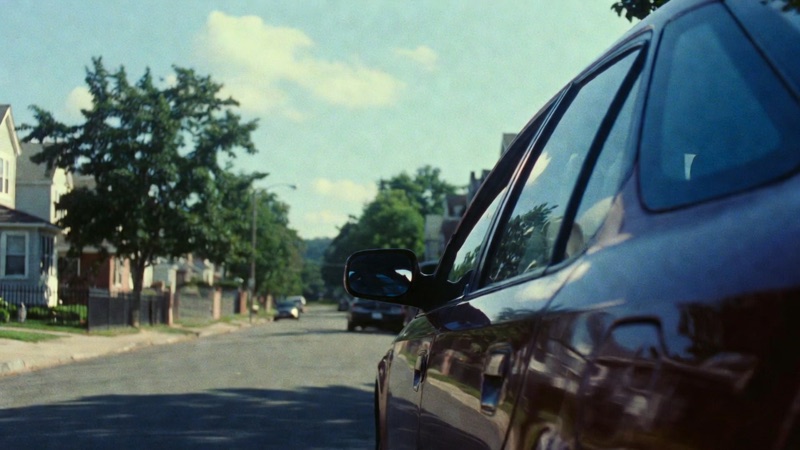 Passenger Side · by Felix · over-the-fender view, parked car close-up, leafy street